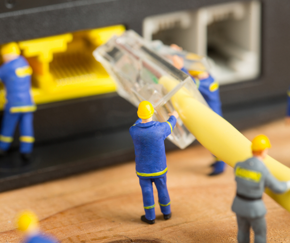 Symbolic image of miniature technicians installing network cable – representing precise apartment-level fiber connections and socket setup by S&S Solutions GmbH