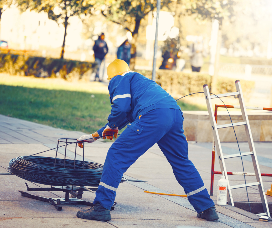 FTTH field technician working on outdoor cable deployment – representing S&S Solutions GmbH’s responsible and precise project execution in public spaces